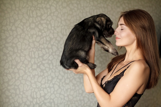 Adorable cachorro de un pug en manos de una bella mujer