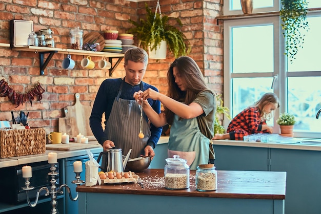 Adorable familia juntos cocinando el desayuno en la cocina estilo loft.