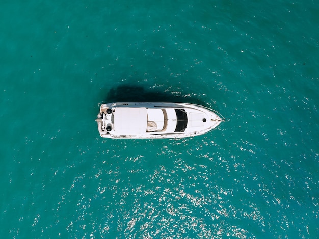 Adorable foto aérea de la vista superior de un enorme yate de dos pisos navegando a través del mar azul profundo