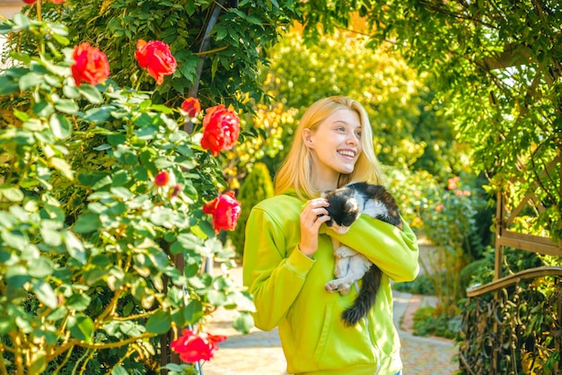 Adorable gato de abrazo de chica rubia de moda. Disfruta la temporada de otoño. Otoño está aquí. Mujer bonita lleva animal gato. Fondo de naturaleza de animales de amor de mujer. Calidez y comodidad. Feliz día de otoño con un amigo