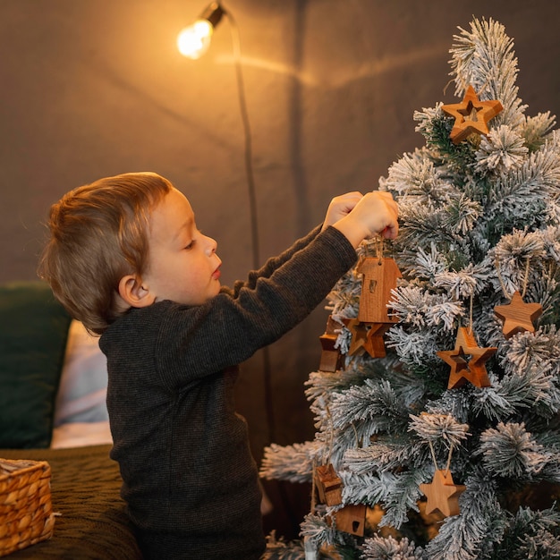 Foto adorable joven decorar el árbol de navidad