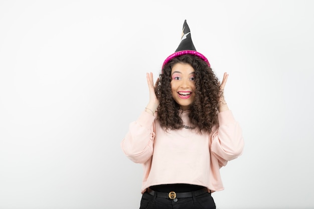 Adorable joven con pelo rizado con sombrero especial para fiesta.