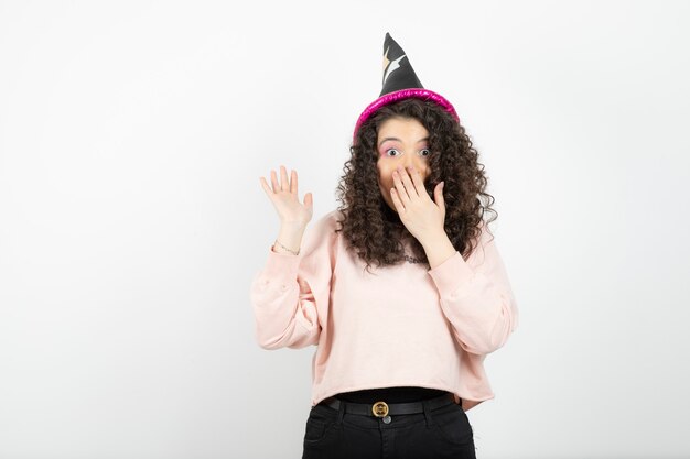 Adorable joven con pelo rizado con sombrero especial para fiesta.