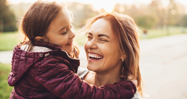 Adorable madre y su niña riendo durante un paseo de verano