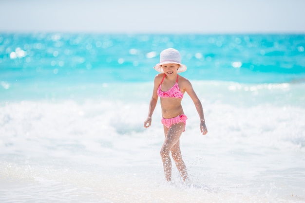 Adorable niña activa en la playa durante las vacaciones de verano