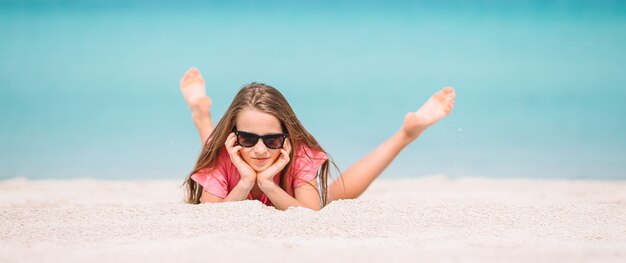 Adorable niña activa en la playa durante las vacaciones de verano