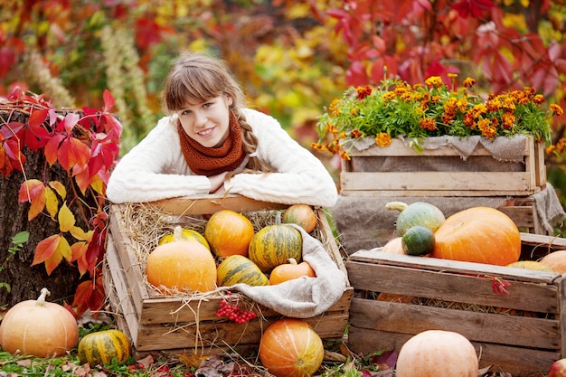 Adorable niña adolescente con calabazas en el parque otoño. Actividades de otoño para niños. Diversión de Halloween y Acción de Gracias para la familia.