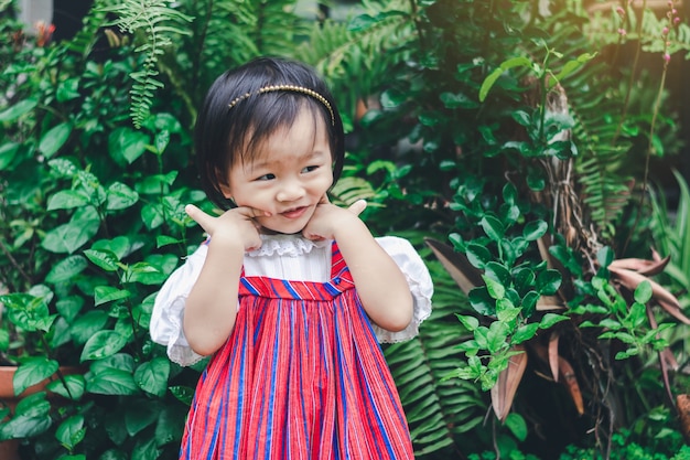 Adorable niña asiática disfruta de jardín en casa