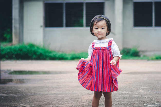 Adorable niña asiática disfruta de jardín en casa