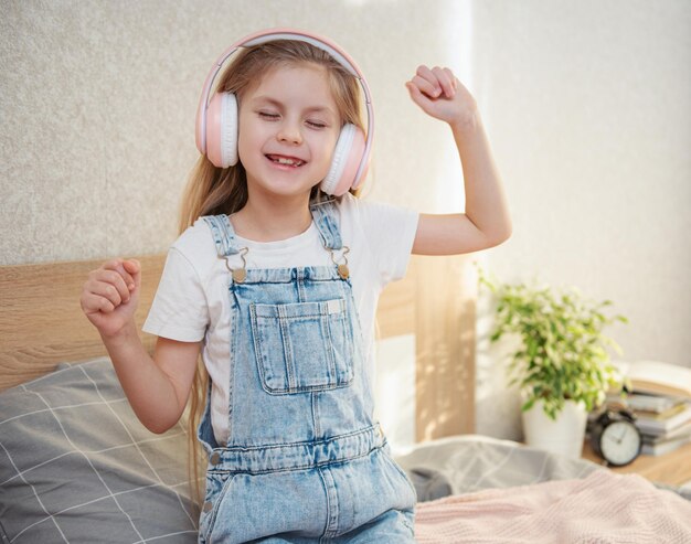 Adorable niña en auriculares disfruta con una música