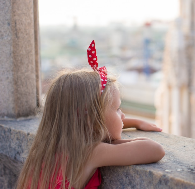 Adorable niña en la azotea del Duomo, Milán, Italia