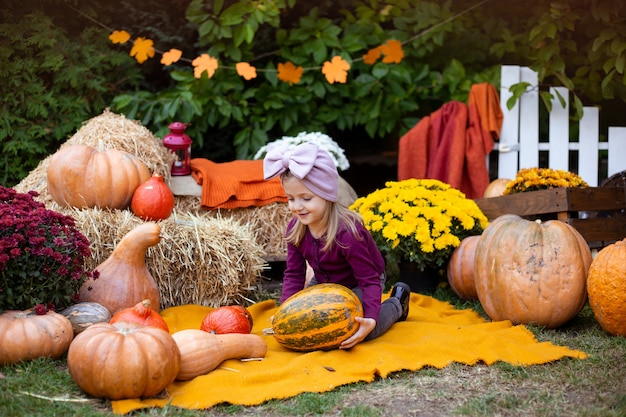 Adorable niña con calabaza al aire libre