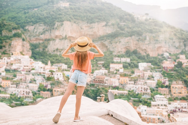 Adorable niña en un cálido y soleado día de verano en la ciudad de Positano en Italia