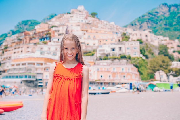 Adorable niña en un cálido y soleado día de verano en la ciudad de Positano en Italia