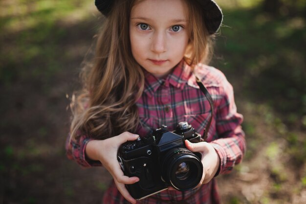 Adorable niña con cámara