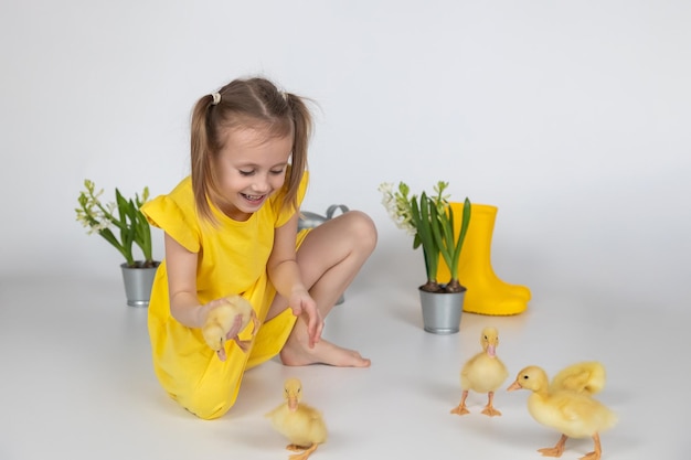 Adorable niña caucásica en edad escolar sosteniendo un lindo patito en las manos