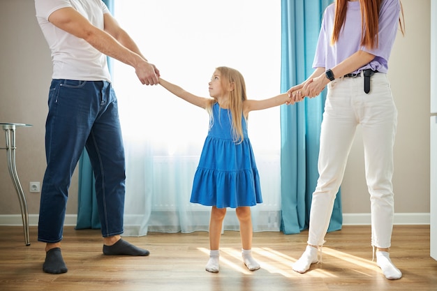 Adorable niña caucásica entre padres deprimidos