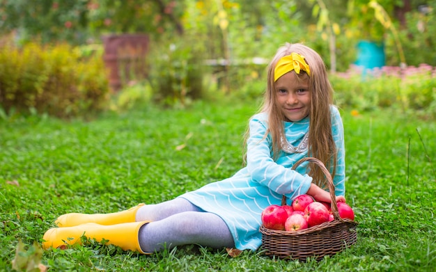 Adorable niña con cesta de cosecha de otoño