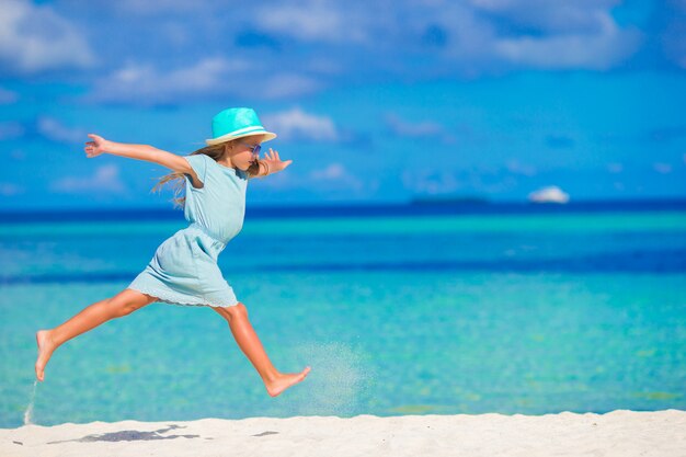 Adorable niña corriendo en tropical playa blanca