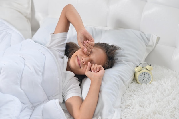 Adorable niña despierta en su cama