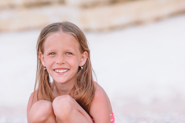 Adorable niña divertirse en la playa tropical durante las vacaciones