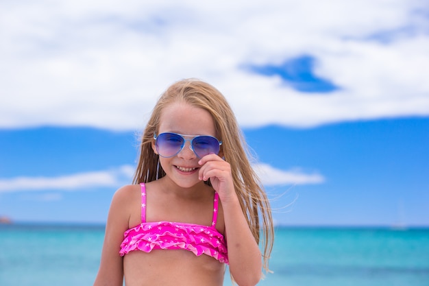 Adorable niña divertirse en la playa tropical durante las vacaciones