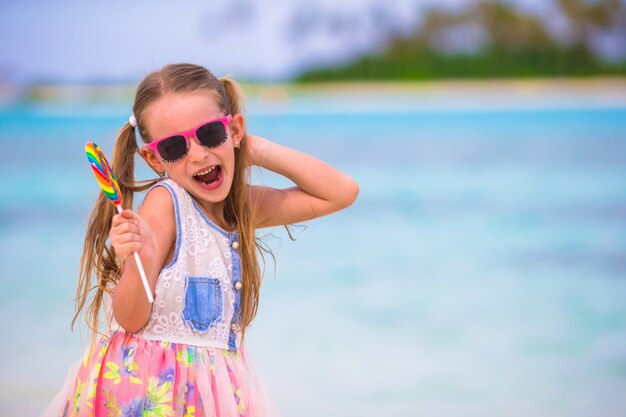 Adorable niña diviértete con paleta en la playa