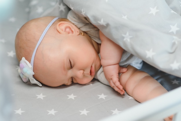 Adorable niña durmiendo en la cuna. Niño tomando una siesta en la cuna. Cabrito descansando en vivero