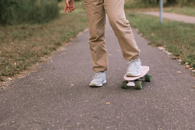 Adorable niña feliz montando patineta en el parque