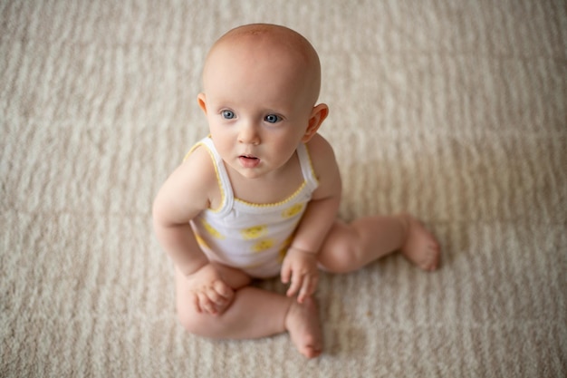 Adorable niña feliz sentada en una alfombra peluda en casa