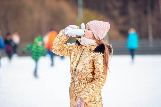 Adorable niña feliz sledding en día de invierno cubierto de nieve.