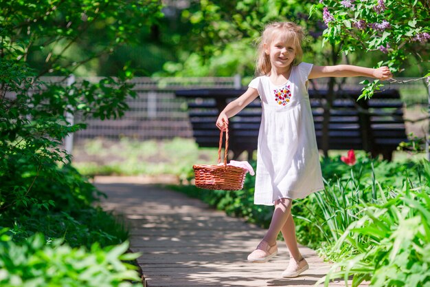 Adorable niña con flores en el jardín de tulipanes