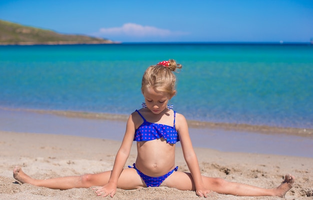 Adorable niña haciendo rueda en tropical playa de arena blanca