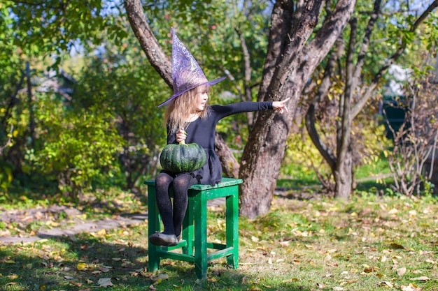 Adorable niña en halloween cuyo disfraz se divierte al aire libre