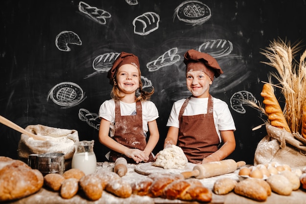 Adorable niña con hermano cocinando