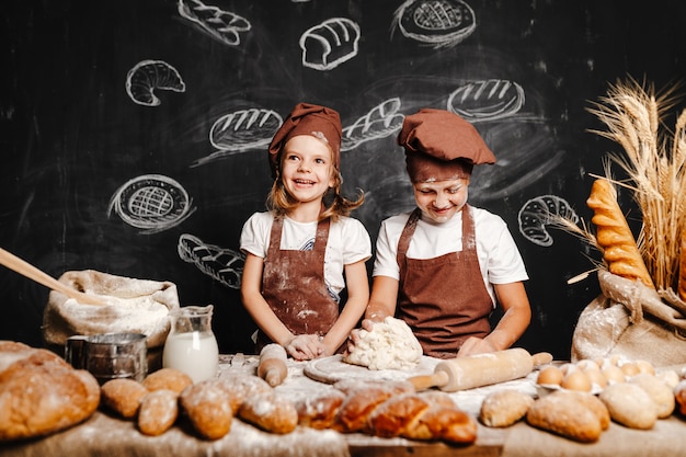 Adorable niña con hermano cocinando