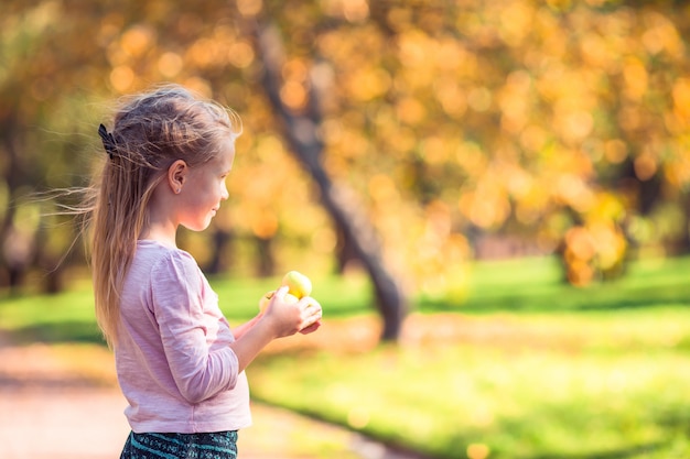 Adorable niña en el hermoso día de otoño al aire libre