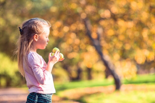 Adorable niña en el hermoso día de otoño al aire libre