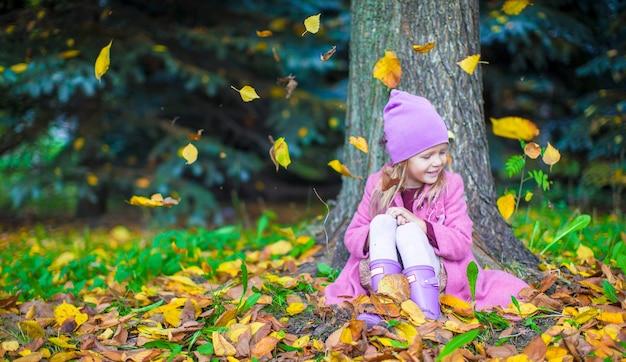 Adorable niña en el hermoso día de otoño al aire libre