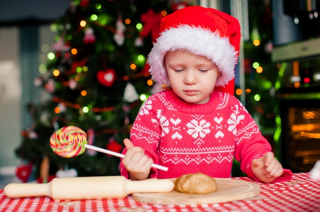 Adorable niña horneando galletas de jengibre de Navidad