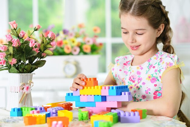 Adorable niña jugando con coloridos bloques de plástico