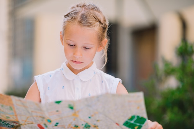 Adorable niña leyendo un mapa