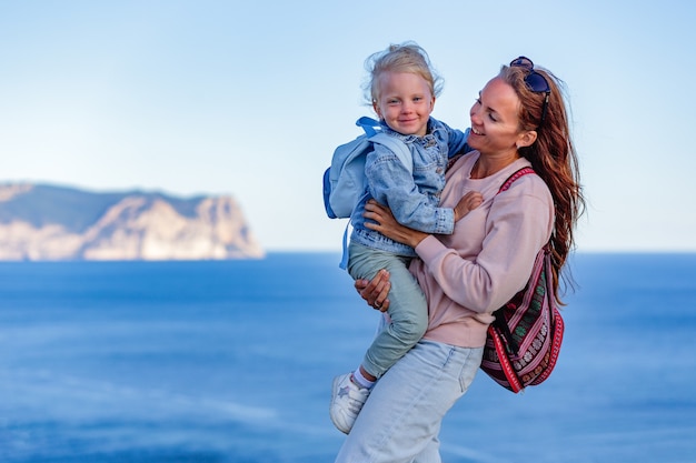 Adorable niña y madre feliz en vacaciones de verano