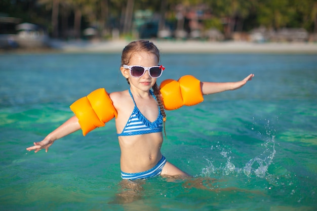 Adorable niña en el mar en vacaciones en la playa tropical