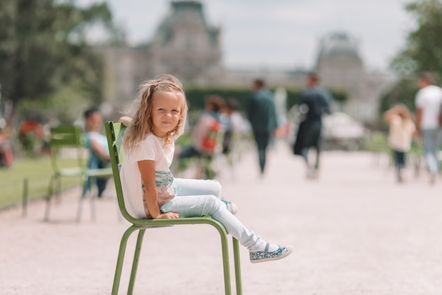 Adorable niña de moda al aire libre en los jardines de las Tullerías, París