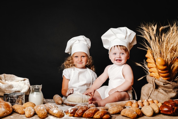 Adorable niña con niño en la mesa de cocina