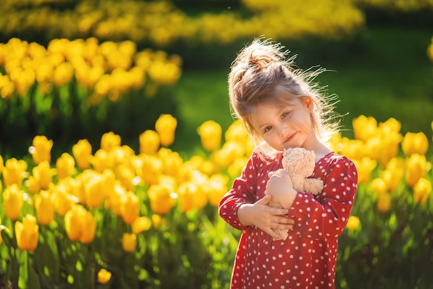 Adorable niña con oso de peluche en el parque