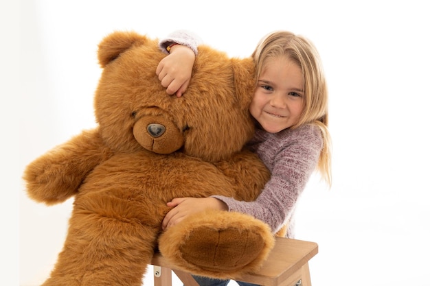 Adorable niña con oso de peluche rojo