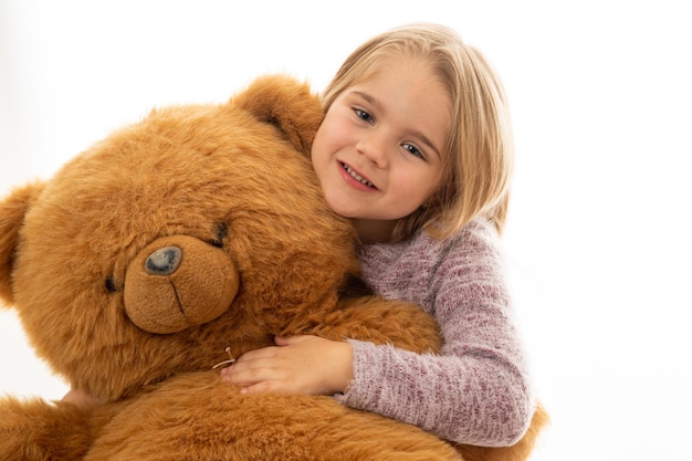 Adorable niña con oso de peluche rojo