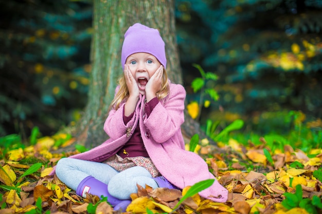 Adorable niña en el parque otoño en día soleado de otoño